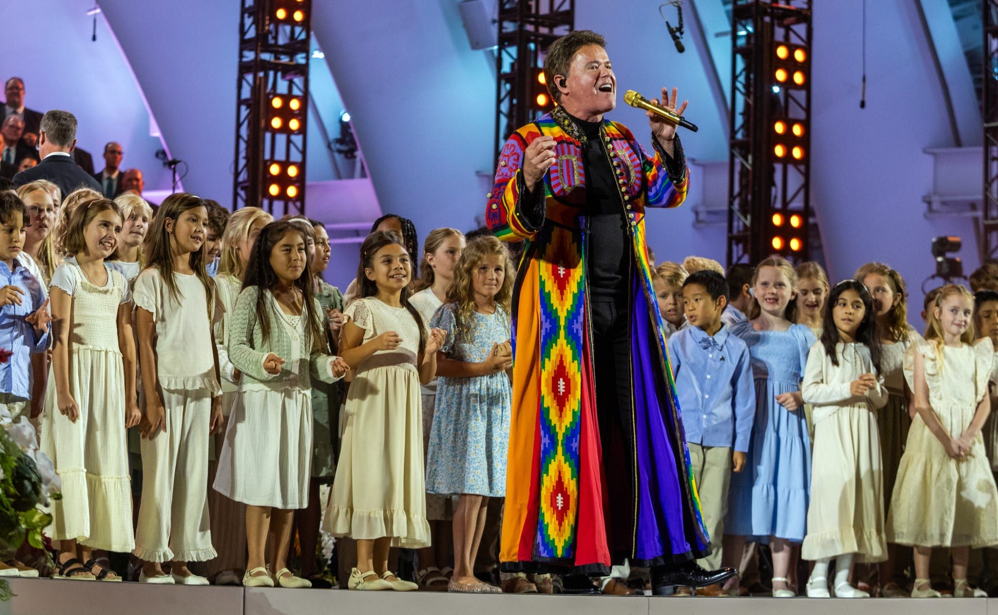 Elder Gérald Caussé of the Quorum of the Twelve Apostles and his wife, Valérie, applaud during the Choir’s concert at the Hollywood Bowl on Thursday, June 25, 2026.